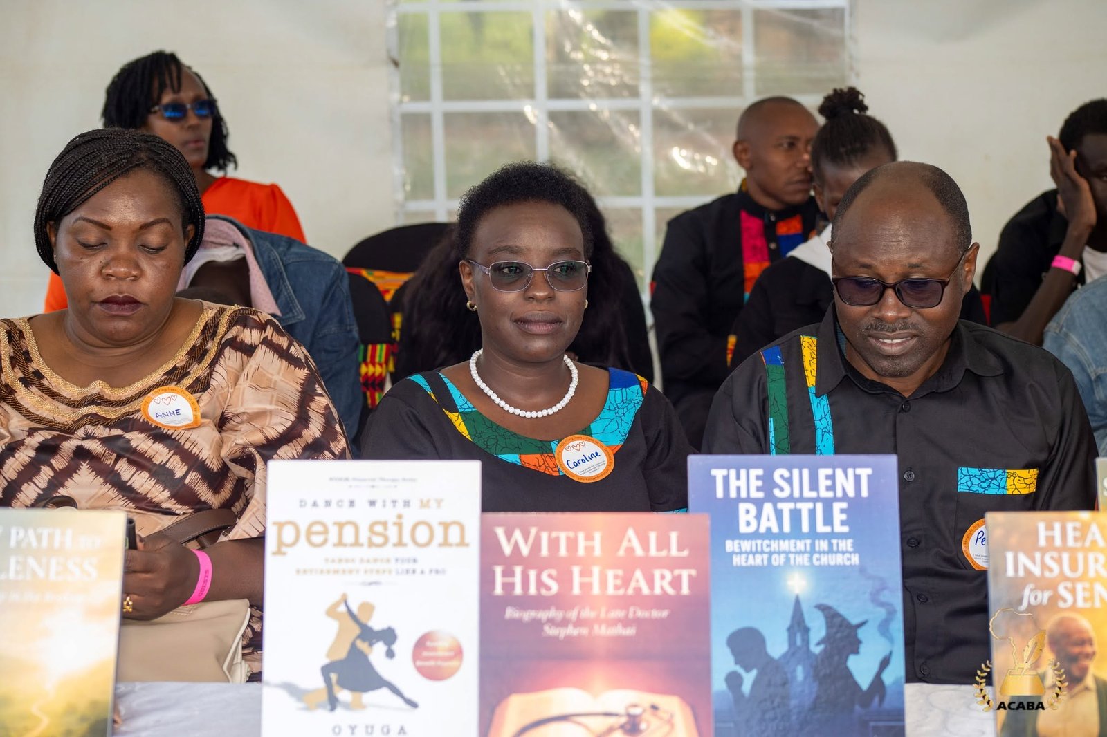 African author holding a published book